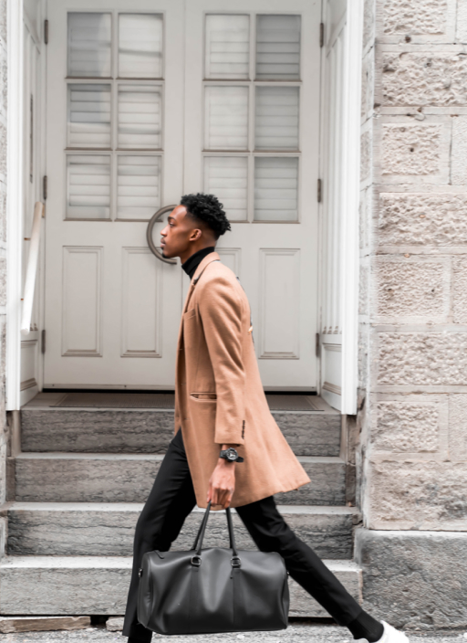 A man on a coat carrying a hand bag